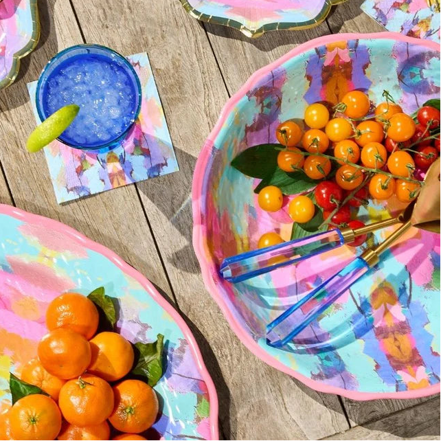 Colorful paper plates with food on a wooden table