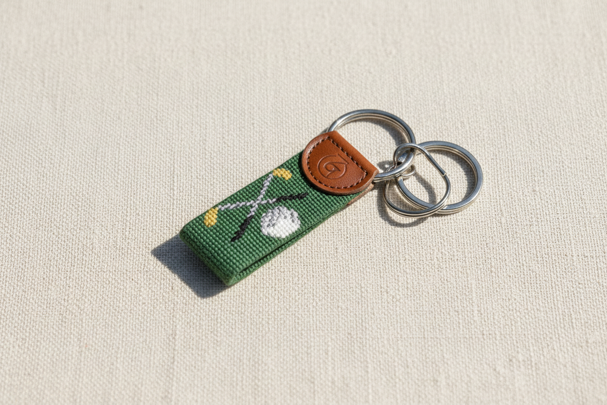 Lifestyle photo of golf needlepoint keychain on linen