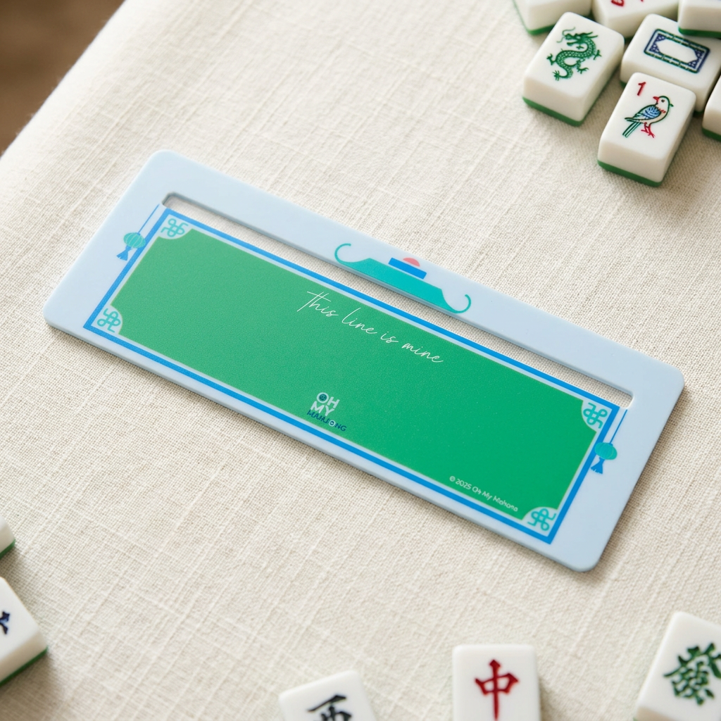 Oh My Mahjong light blue and green line finder on an ivory linen game table beside scattered mahjong tiles.
