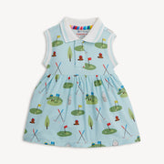 Children's light blue sleeveless dress with white knot collar and arm opening. golf pattern with golf clubs, flags and greens on a white background