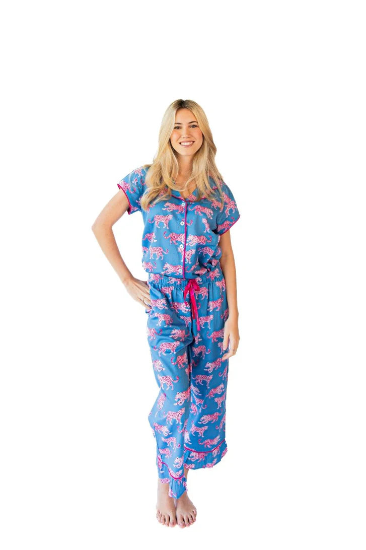woman in blue and pink leopard print pajamas on a white background