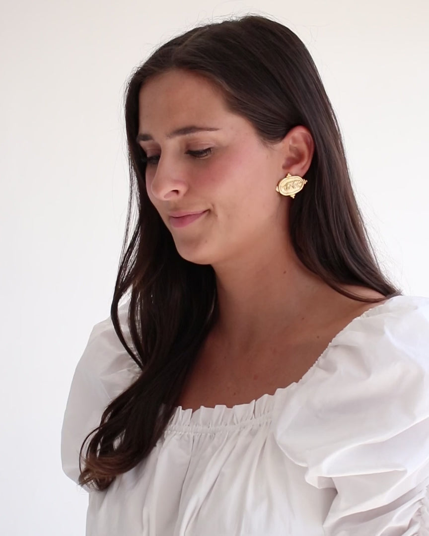 Load video: Video of woman in a white top on white background wearing Susan Shaw gold stud Tiger errings