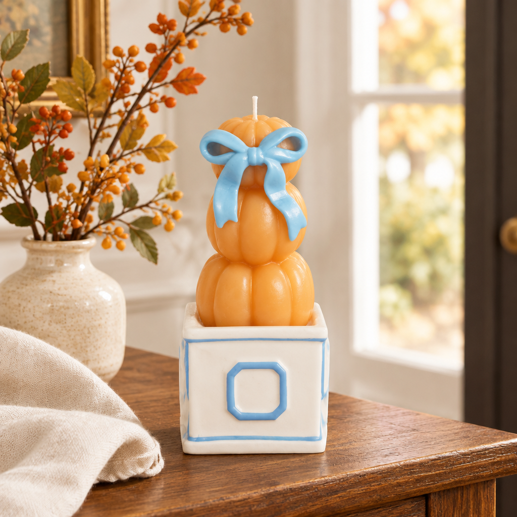 Pumpkin topiary candle styled on a fall entryway console