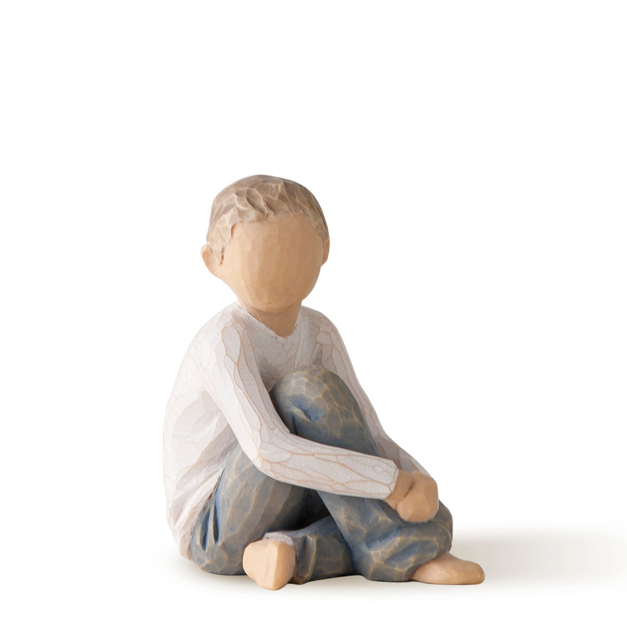 Sculpture of a child sitting on a white background