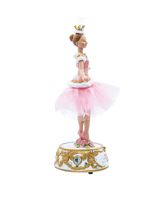 Doll in a pink dress with a crown on a white background