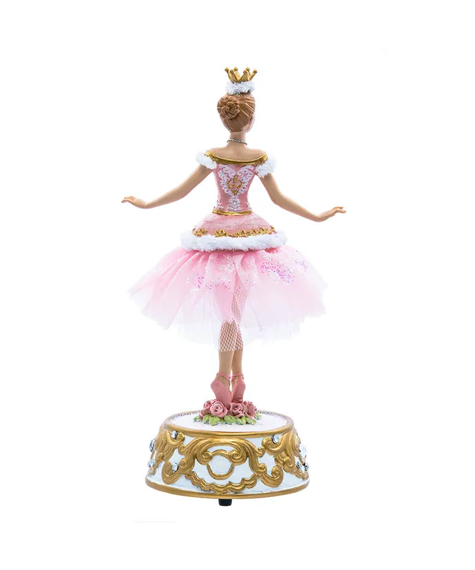 Doll in a pink ballerina outfit with a crown on a white background