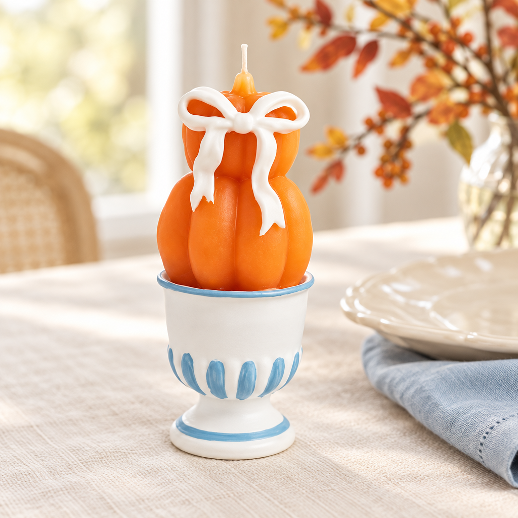 Two-pumpkin candle styled on a fall dining table