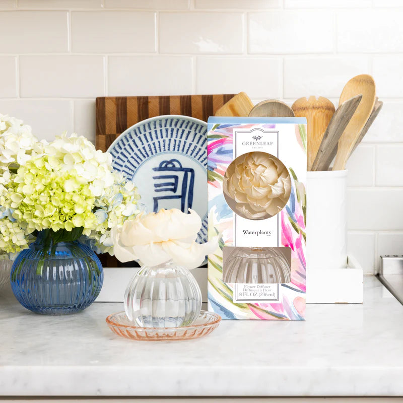 Kitchen counter with decorative items including a vase, flowers, and a product packaging.
